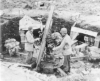 Troops looking over a captured Japanese gun emplacement. May 1943.  [George Villasenor]