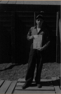 George Villasenor holds copoy of the "Attu Morning Sun," headlines: Japs Quit!" Attu, 14 Aug 1945  [George Villasenor