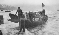 Scene at Attu's Massacre Bay beach; Americans bring ashore a captured Jap landing boat. [U. S. Navy Photo]