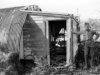 Seems  like it's Rene Thibault, on Attu...but  what has happened to the building?  Ah, a little tomfoolery by HLS's  graphics artist, Nadine Smith. The building photo  was shot in 1995, while Rene's photo was from 1946!  [Rene Thibault & Nadine Smith]