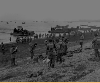 Southern landing force disembarking at Attu's Massacre Bay; landing boats pour scores of soldiers onto a sandy beach. 11 May 1943. [George & Nadine Smith]