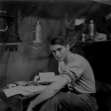 On Attu, my home for several years, taken inside the hut. Looks as if I'm writing home or to some girl! [Al Gloeckler]