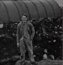 46. Al outside of a Quonset hut on Attu. The huts had to be dug in 3 feet because the wind was so strong. [All Gloeckler]