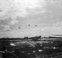 Attu. Four P-38s enjoying the good weather, which was rare indeed. Most of the time we stayed inside! That is another P-38 and a P-40 parked on the ground. [Al Gloeckler]